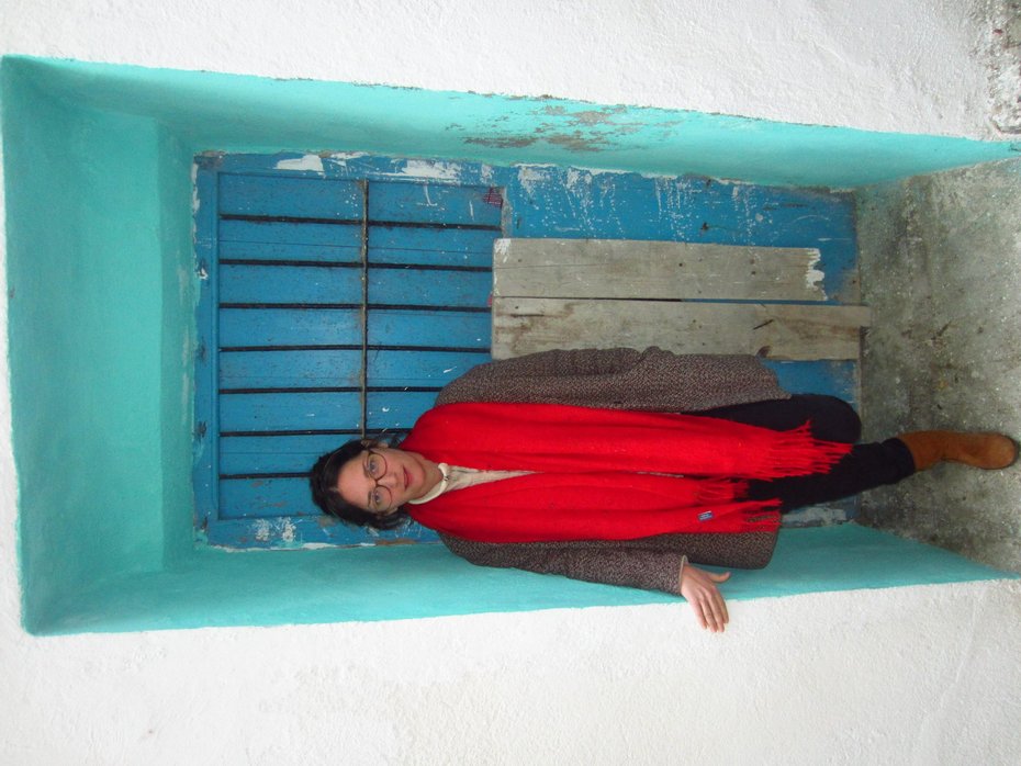 Sandra Illana con bufanda roja en una puerta azul
